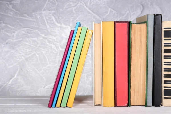 Knihy na dřevěný stůl na světlé pozadí — Stock fotografie