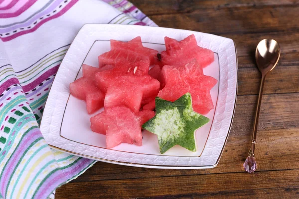 Melone und Wassermelone in Teller auf Serviette auf Holzgrund — Stockfoto
