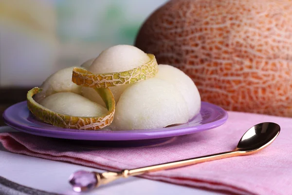 Melone im Teller auf Serviette auf Schneidebrett auf Holztisch auf natürlichem Hintergrund — Stockfoto