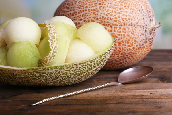 Melone in Melonenschale auf Holztisch vor natürlichem Hintergrund — Stockfoto