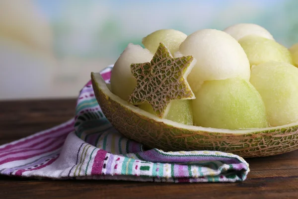 Melone in Melonenschale auf Serviette auf Holztisch auf natürlichem Hintergrund — Stockfoto