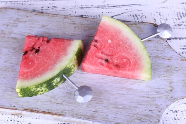Slices of watermelon on cutting board on wooden background — Stock Photo, Image