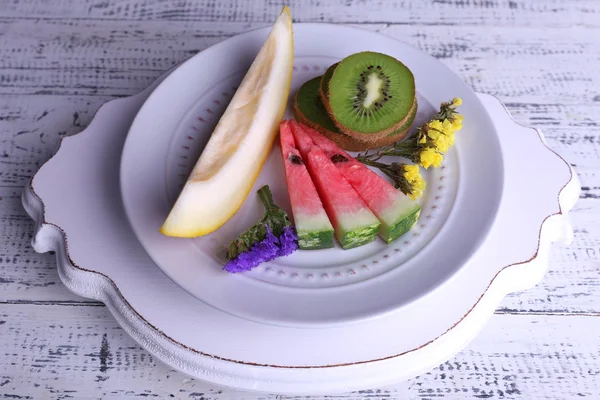 Rodajas de melón, kiwi y sandía en plato sobre fondo de madera —  Fotos de Stock