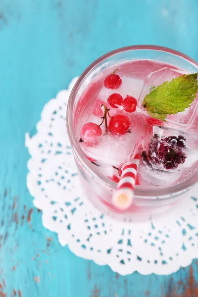 Kyla cocktail med skogsbär, frysta i isbitar på färg trä bakgrund — Stockfoto