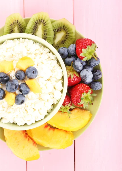 Cottage cheese with fruits and berries in bowl on wooden table — Stock Photo, Image