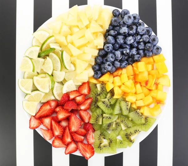 Rebanadas de frutas en el plato en la mesa —  Fotos de Stock