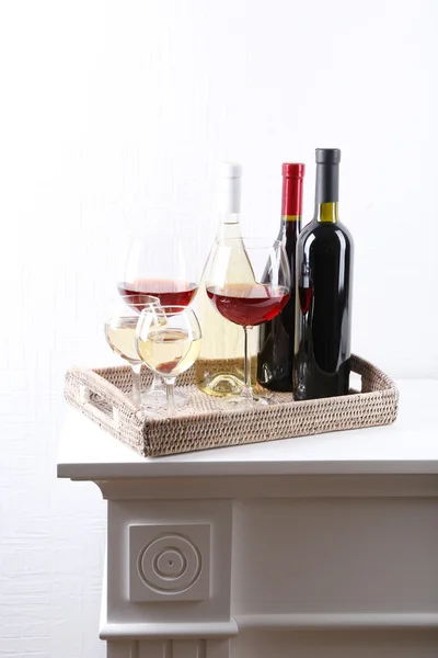 Bottles and glasses of wine on table in room — Stock Photo, Image