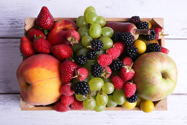 Distintas bayas y frutas en primer plano de mesa de madera —  Fotos de Stock