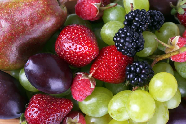 Different berries and fruits close-up background — Stock Photo, Image