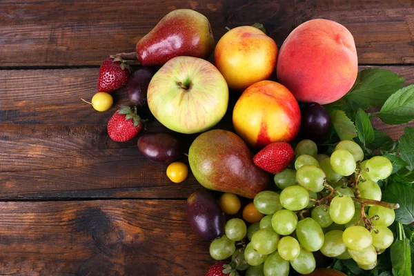 Verschillende bessen en fruit op houten tafel close-up — Stockfoto