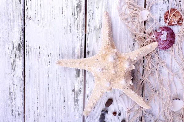 Decor of seashells and seastar close-up on blue wooden table — Stock Photo, Image