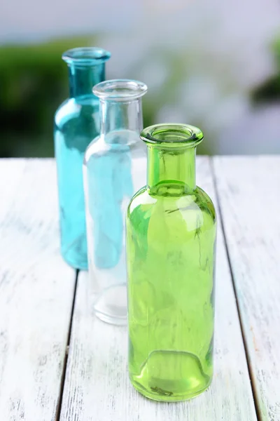 Leere Glasflaschen auf Tisch vor hellem Hintergrund — Stockfoto