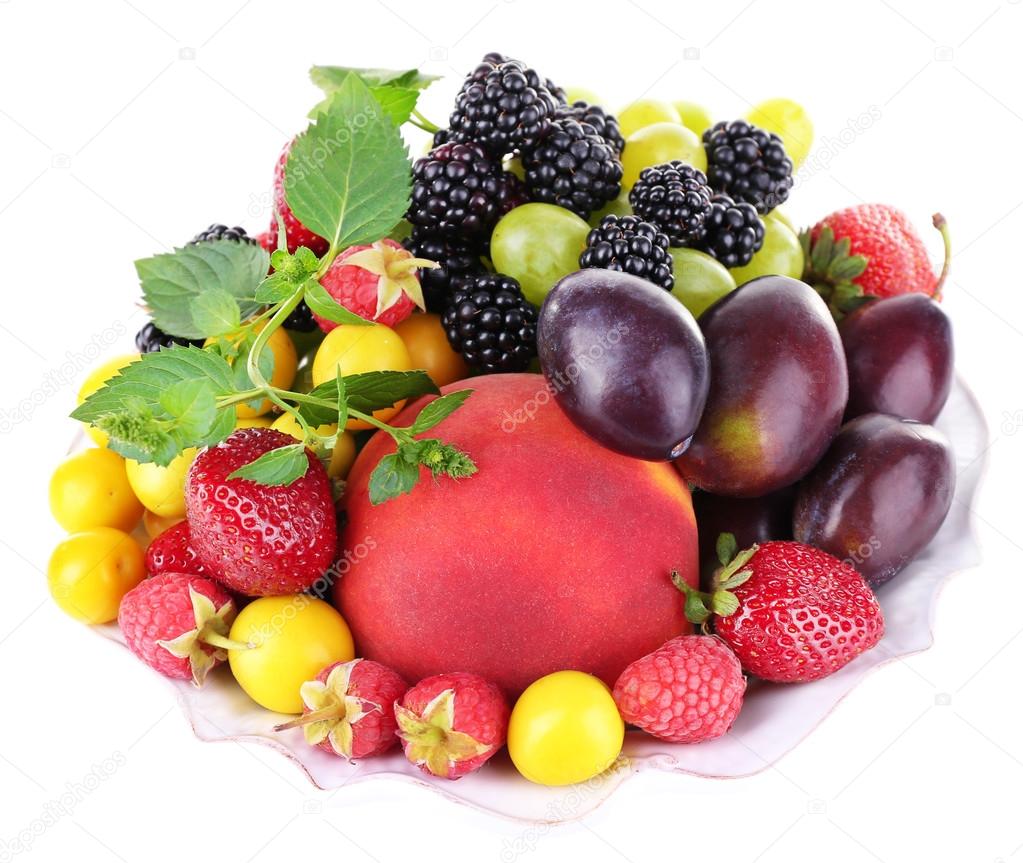 Different berries and fruits in plate isolated on white