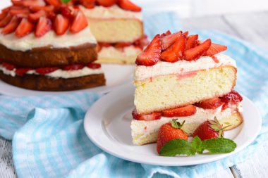 Delicious biscuit cake with strawberries on table close-up clipart