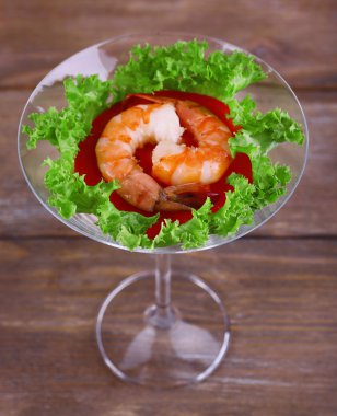 ahşap zemin üzerinde bir kadehi marulla taze haşlanmış karides