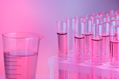 test tüpleri ve bardak ile Lila zemin üzerine sıvı