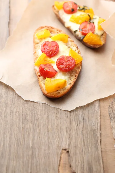 Sabrosa bruschetta con tomates, sobre una vieja mesa de madera —  Fotos de Stock