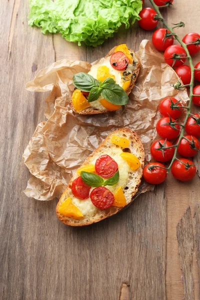 Smakelijke bruschetta met tomaten, op oude houten tafel — Stockfoto