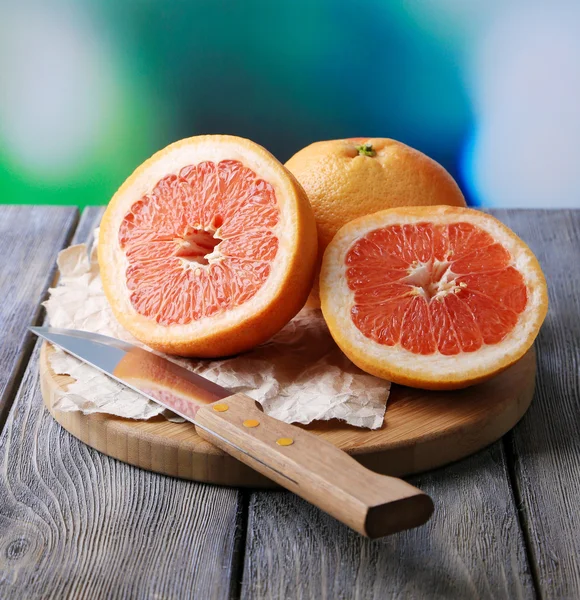 Rijp grapefruits op houten bord, op lichte achtergrond — Stockfoto