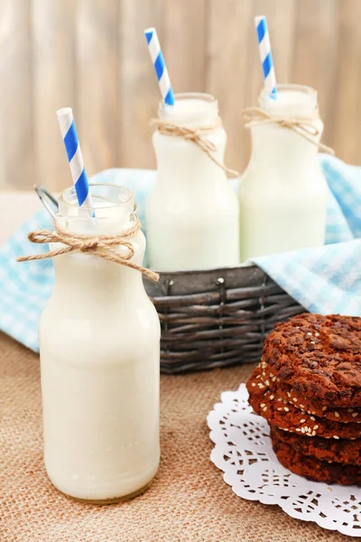 Milk in bottles with paper straws on table — Stock Photo, Image