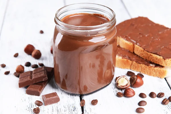 Sweet chocolate cream in jar on table close-up — Stock Photo, Image