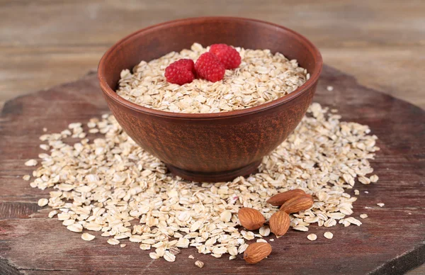 Mangkuk coklat besar dengan oatmeal dan berry di atas meja kayu — Stok Foto