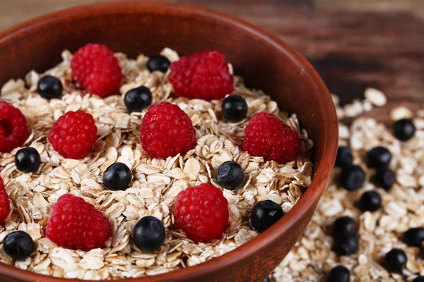 Braun Schüssel mit Haferflocken und Beeren auf einem Holztisch — 图库照片