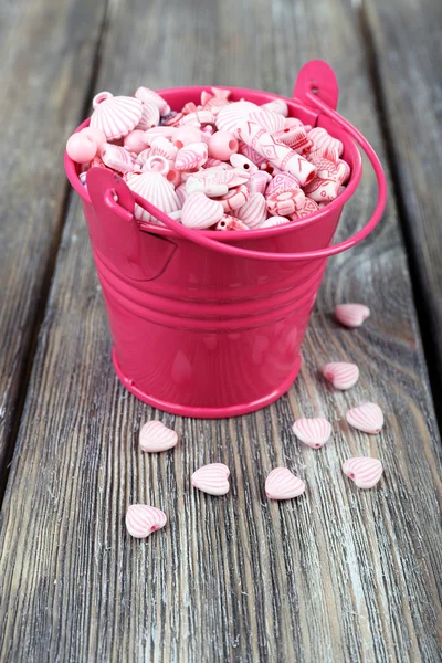 Beads in metal bucket on wooden background — Stock Photo, Image