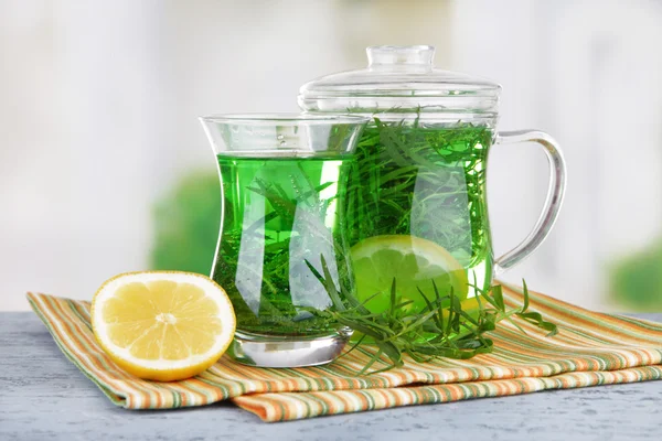 Estragon drink on bamboo mat on wooden table on bright background — Stock Photo, Image