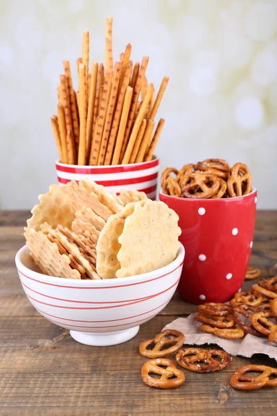 Trockenes Frühstück, Sticks und Kekse in roter Tasse und Teller auf einem Holztisch — Stockfoto