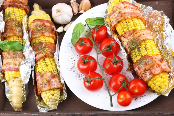 Tocino a la parrilla envuelto maíz en la mesa, primer plano — Foto de Stock