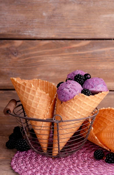 Sabroso helado con bayas en cono de gofre sobre fondo de madera marrón —  Fotos de Stock