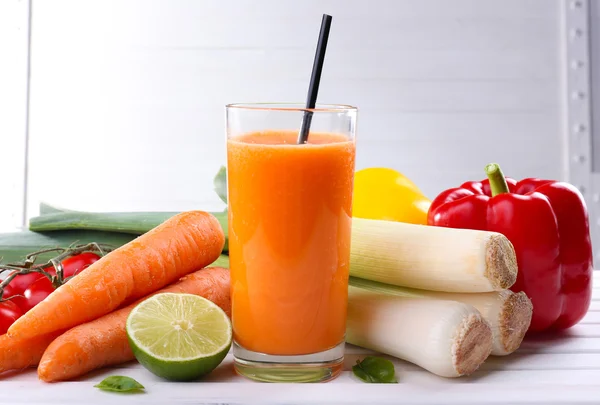 Copo de suco de cenoura fresca e legumes na mesa de madeira — Fotografia de Stock