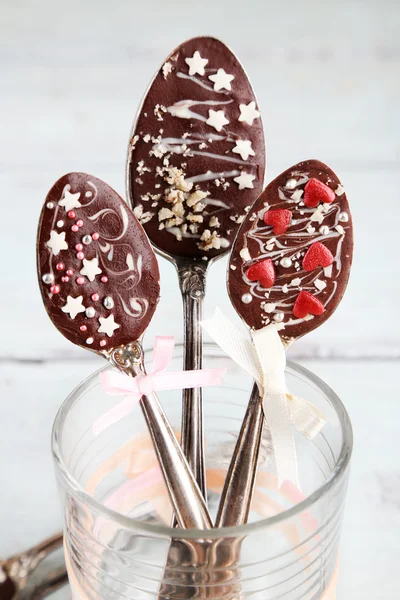 Cucchiai con gustoso cioccolato per festa su vecchio tavolo di legno — Foto Stock