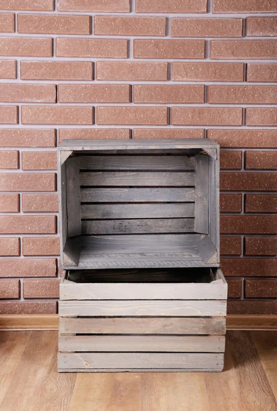 Cajas de madera rectangulares en el suelo frente a la pared de ladrillo —  Fotos de Stock