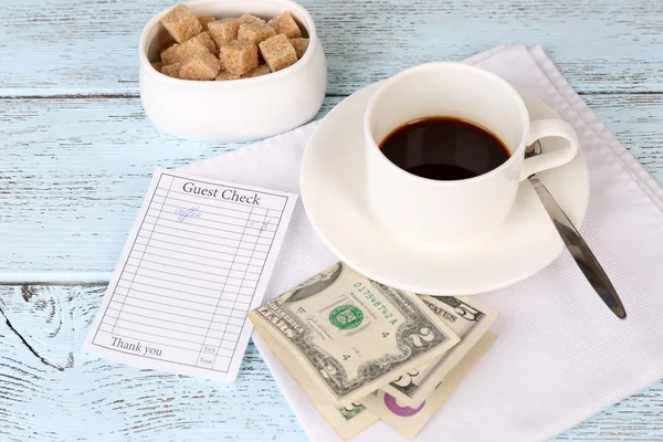Cheque, dinheiro e xícara de café na mesa close-up — Fotografia de Stock