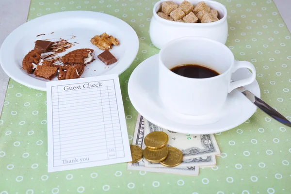 Verifique, xícara de café e dinheiro na mesa de close-up — Fotografia de Stock