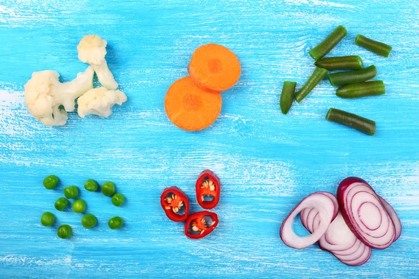 Different kind of raw vegetables on wooden table — Stock Photo, Image