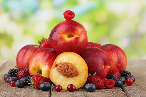 Peaches with berries on table — Stock Photo, Image