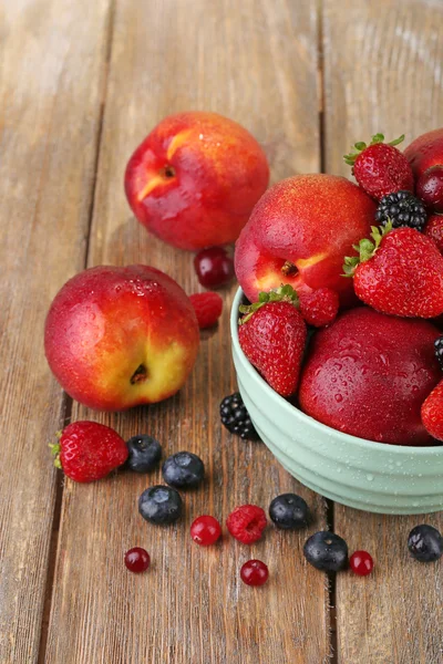 Peaches and berries in bowl — Stock Photo, Image