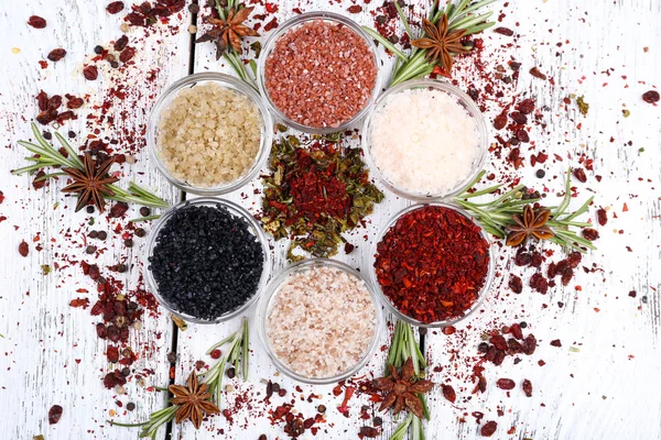 Spices in glass round bowls with herbs on wooden background — Stock Photo, Image