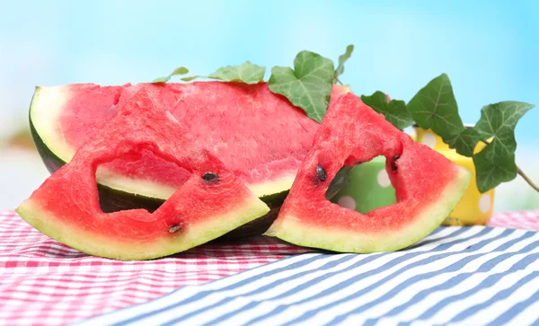 Verse plakjes van watermeloen op tafel, op blauwe achtergrond — Stockfoto