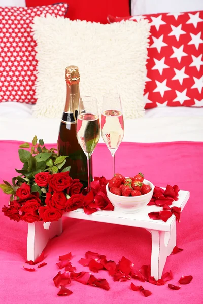 Romântico ainda vida com champanhe, morango e rosas na cama — Fotografia de Stock