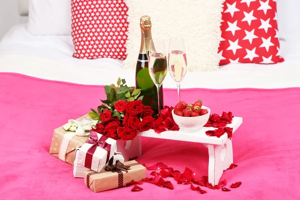 Романтический натюрморт с шампанским, клубникой и розами на кровати — стоковое фото