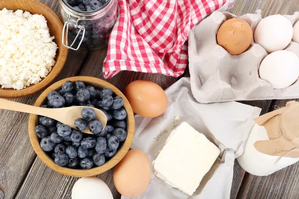 Verse bosbessen en zuivelproducten op houten tafel — Stockfoto