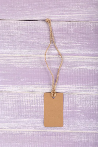 Пустой тег на фиолетовом деревянном фоне — стоковое фото