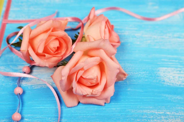 Beautiful roses on blue wooden background — Stock Photo, Image