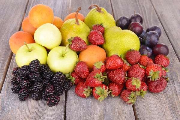 Buah-buahan dan buah-buahan matang dengan latar belakang kayu — Stok Foto