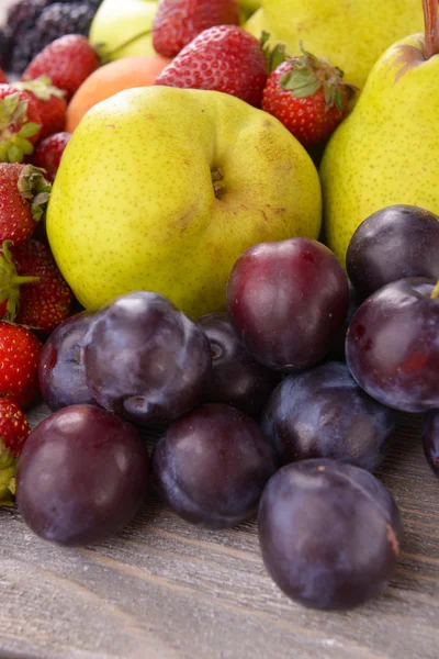 Dojrzałe owoce i truskawki na stole z bliska — Zdjęcie stockowe
