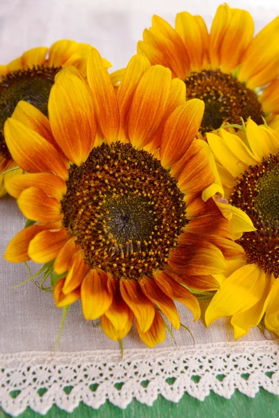 Beautiful sunflowers in pitcher on napkin on table close up — Stock Photo, Image